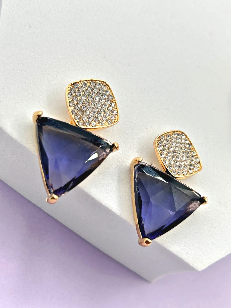 Side view of the Aria purple triangle stud and dangling CZ teardrop earrings on a model's ear, highlighting the gold setting