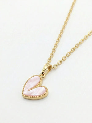 Gold necklace with a pink heart-shaped pendant on a white background