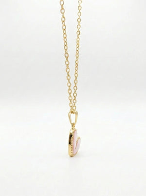 Gold necklace with a pink pendant on a white background