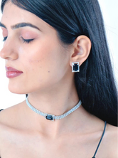 Model wearing a silver choker necklace set with a black stone pendant and matching dangle earrings side shot 