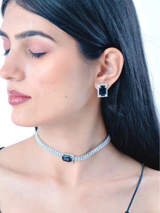 Model wearing a silver choker necklace set with a black stone pendant and matching dangle earrings side shot 